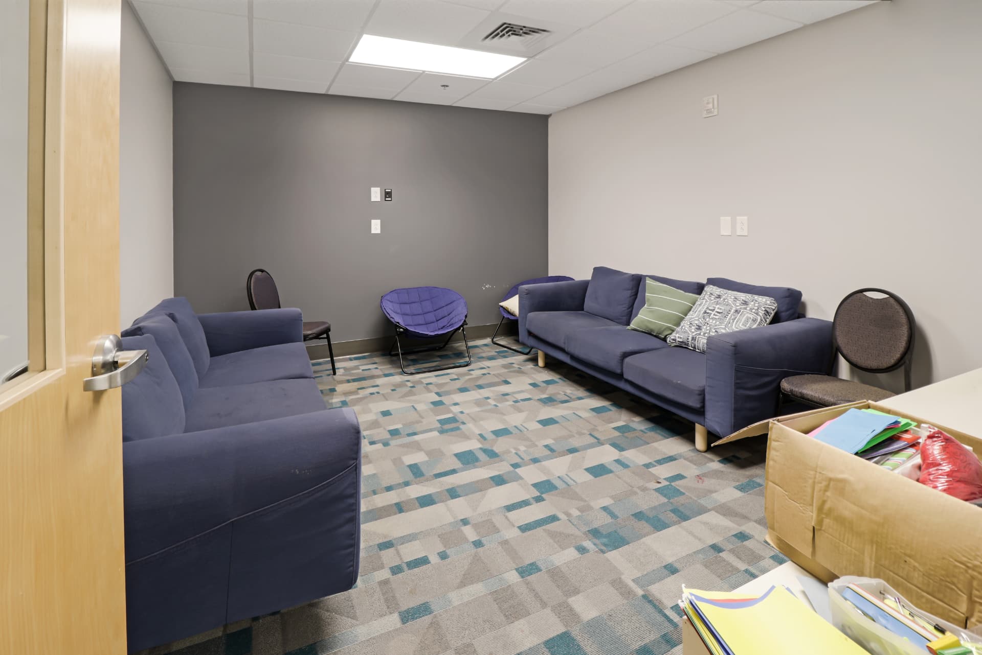 Carpeted lounge and meeting room with seating